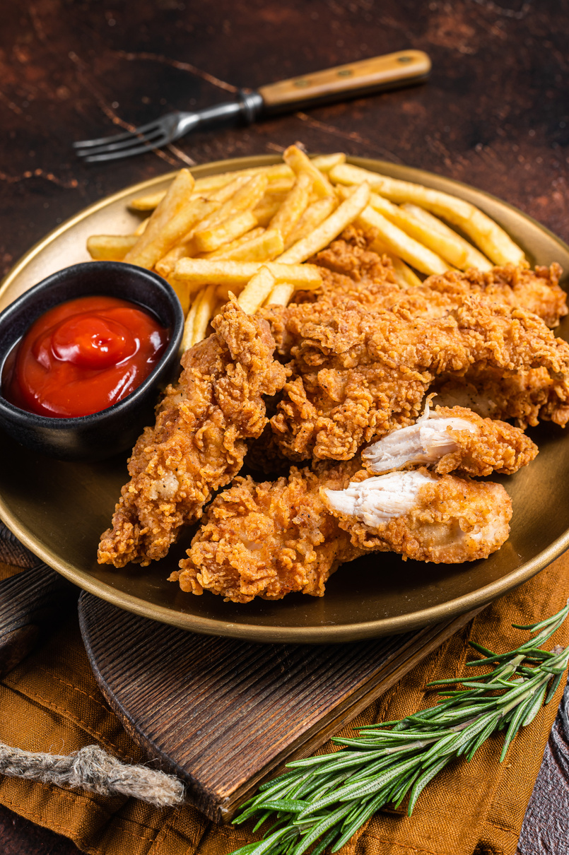Fried Breaded chicken tender strips with french fries and to